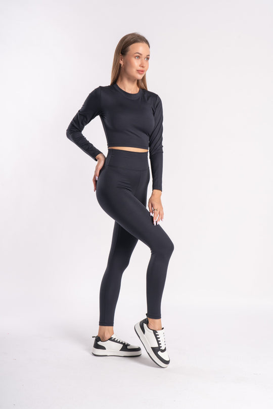 woman wearing a sleek black athletic set of top and bottom